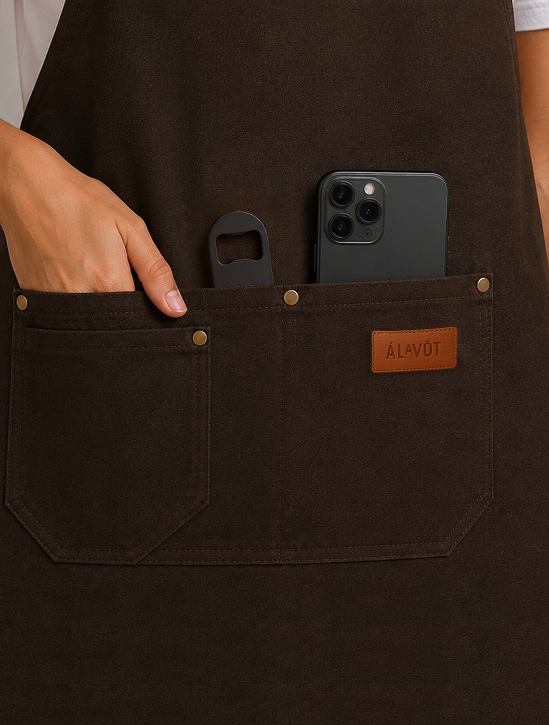 Person wearing a dark apron with a phone and bottle opener in a pocket, brand 'ALAVOT' visible.