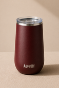 Maroon wine tumbler with silver lid on a beige background